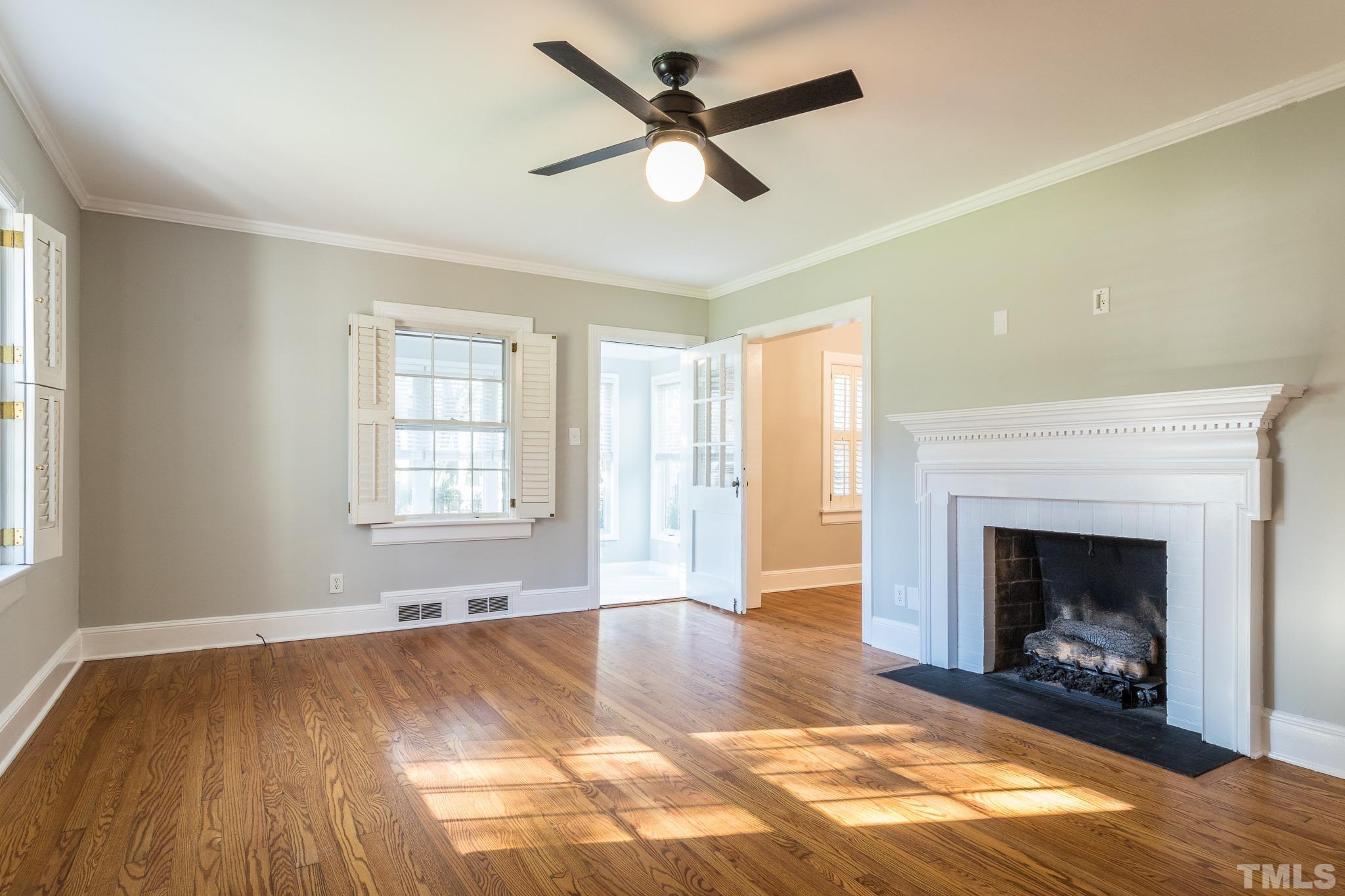 2725 Anderson Drive Raleigh, NC 27608 - Photo 4 of 27 a view of an empty room with a fireplace and a window