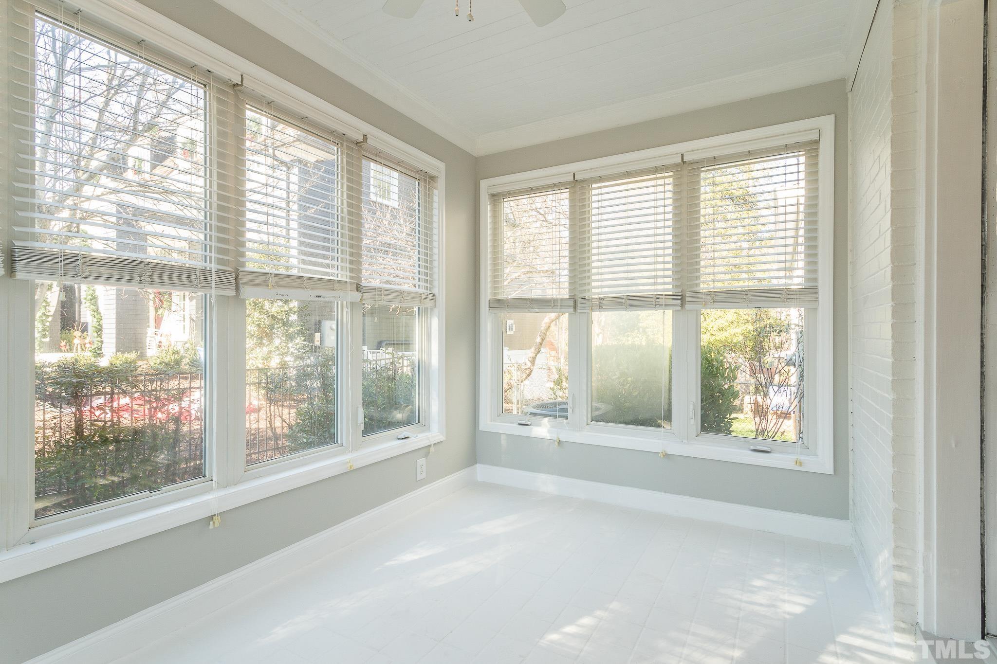 2725 Anderson Drive Raleigh, NC 27608 - Photo 7 of 27 a view of an empty room with wooden floor and a window