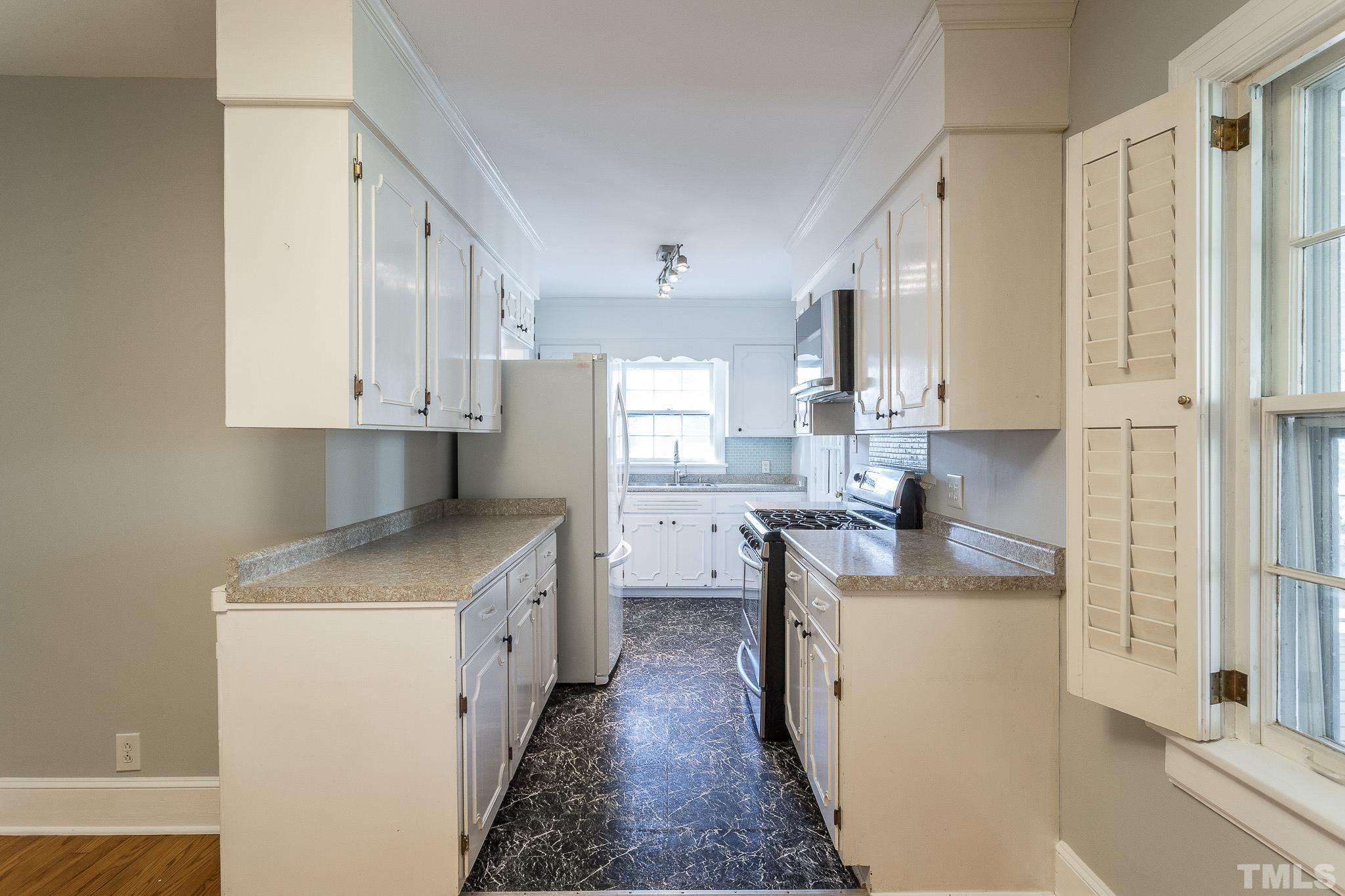 2725 Anderson Drive Raleigh, NC 27608 - Photo 10 of 27 a kitchen with stainless steel appliances granite countertop a sink stove and refrigerator