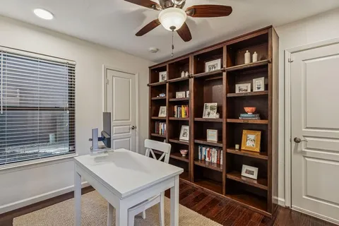 a view of a workspace with furniture and a book shelf