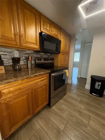 a kitchen with stainless steel appliances granite countertop a stove a sink and a microwave