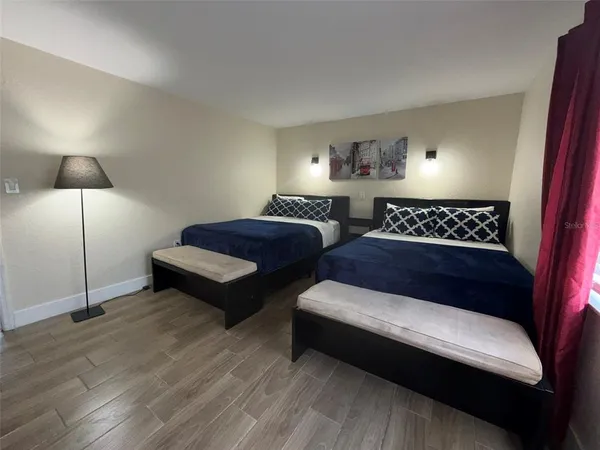 a spacious bedroom with a bed and lamp