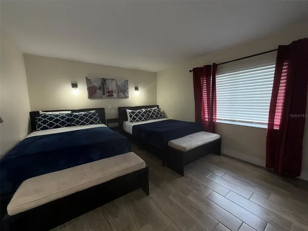 a bedroom with two beds and a window