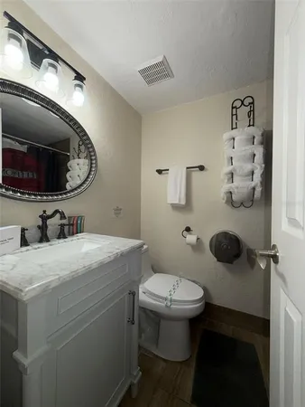 a bathroom with a granite countertop toilet sink and mirror