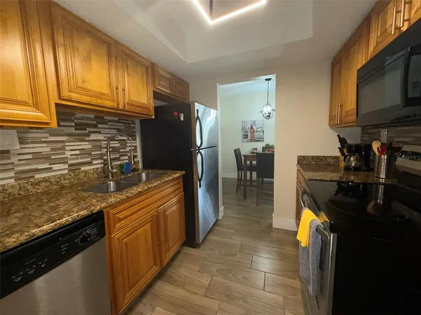 a kitchen with stainless steel appliances granite countertop a sink stove and refrigerator