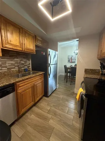 a kitchen with stainless steel appliances granite countertop a sink stove and refrigerator