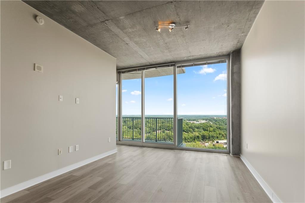 361 17th Street Northwest, Unit 1906 Atlanta, GA 30363 - Photo 2 of 28 an empty room with wooden floor and windows