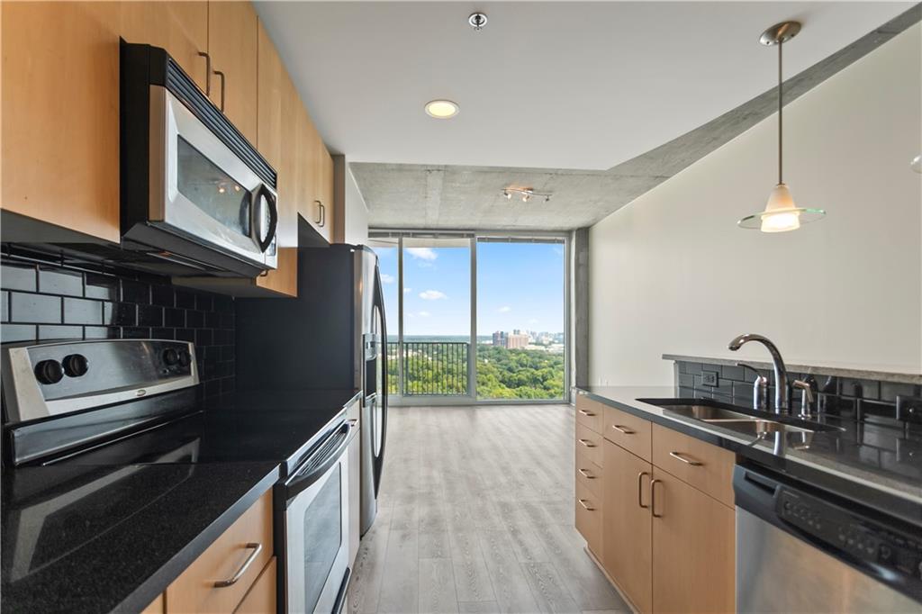 361 17th Street Northwest, Unit 1906 Atlanta, GA 30363 - Photo 5 of 28 a kitchen with kitchen island granite countertop a stove and a sink