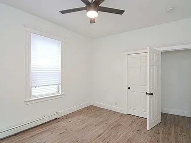 27 Hosmer Street, Unit 2 Boston, MA 02126 - Photo 11 of 20 a view of an empty room with wooden floor and a window