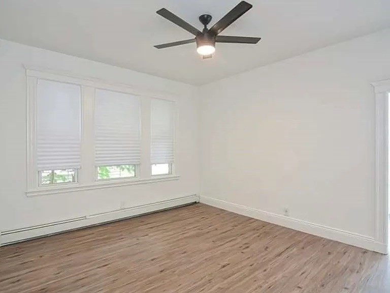 27 Hosmer Street, Unit 2 Boston, MA 02126 - Photo 15 of 20 wooden floor in an empty room with a window