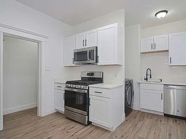 27 Hosmer Street, Unit 2 Boston, MA 02126 - Photo 2 of 20 a kitchen with stainless steel appliances a white stove top oven and cabinets