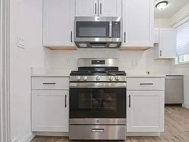 a kitchen with stainless steel appliances granite countertop a stove microwave and cabinets