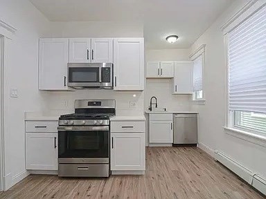 27 Hosmer Street, Unit 2 Boston, MA 02126 - Photo 5 of 20 a kitchen with cabinets stainless steel appliances and wooden floor