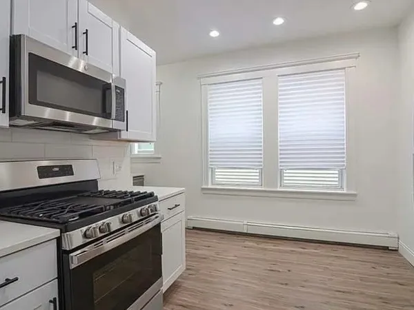 a kitchen with stainless steel appliances a sink a stove a microwave and cabinets