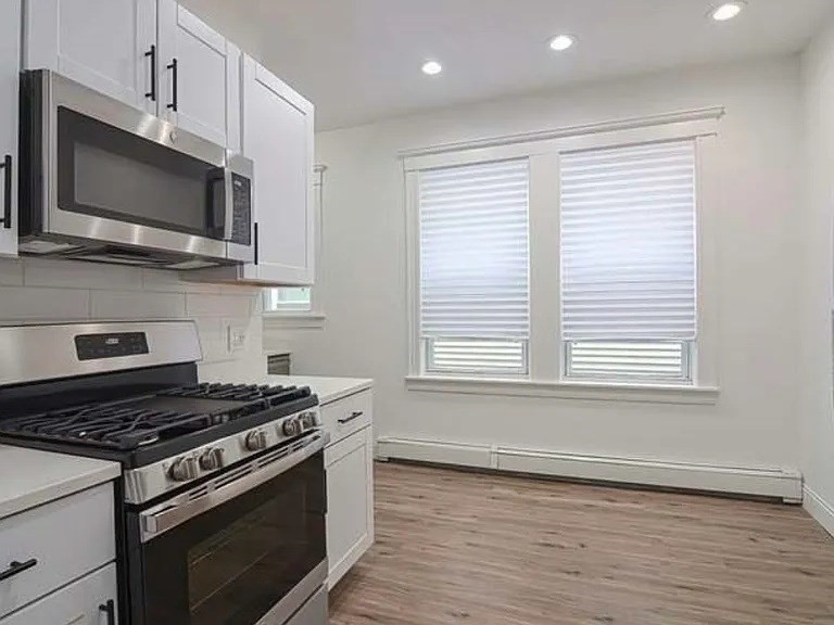 27 Hosmer Street, Unit 2 Boston, MA 02126 - Photo 6 of 20 a kitchen with stainless steel appliances a sink a stove a microwave and cabinets