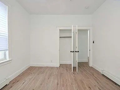 27 Hosmer Street, Unit 2 Boston, MA 02126 - Photo 8 of 20 an empty room with wooden floor & window