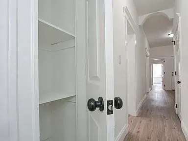 a view of a hallway with wooden floor