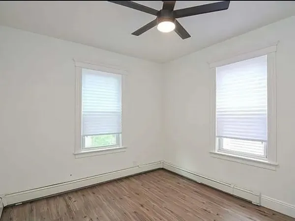an empty room with a window and wooden floor