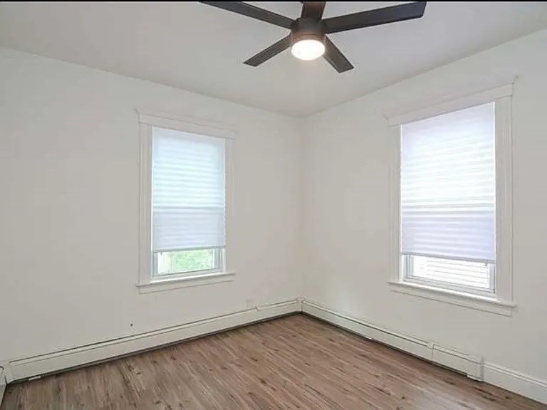27 Hosmer Street, Unit 2 Boston, MA 02126 - Photo 10 of 20 an empty room with a window and wooden floor