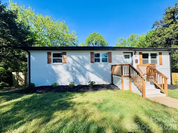 a view of a house with backyard and trees