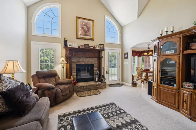 a kitchen with stainless steel appliances granite countertop a refrigerator a stove top oven a sink dishwasher and white cabinets with wooden floor