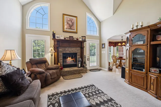 a kitchen with stainless steel appliances granite countertop a stove top oven a sink dishwasher a dining table and chairs with wooden floor