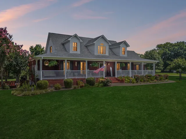 a view of a house with potted plants and a bench