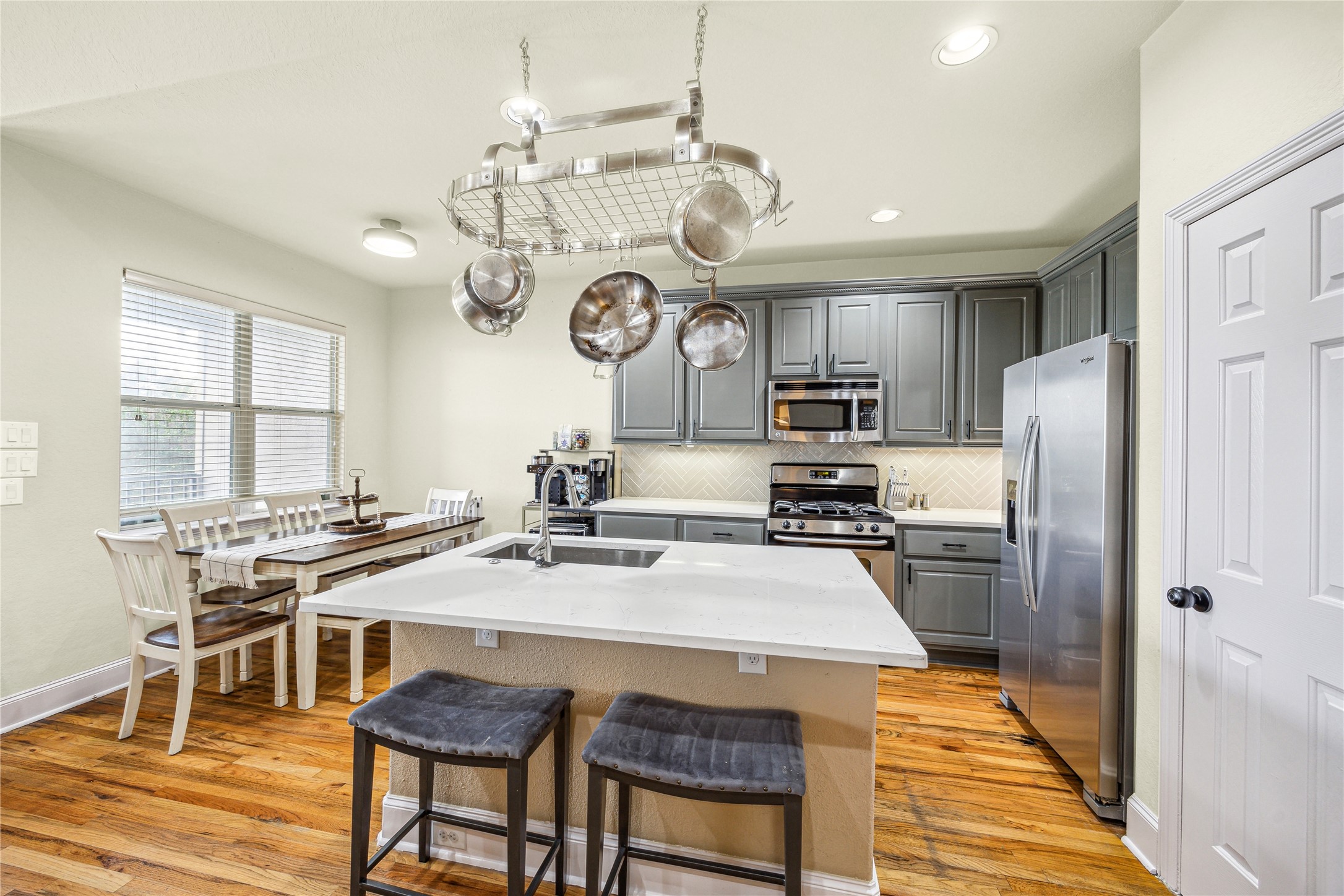 210 Grove Street Houston, TX 77020 - Photo 10 of 28 a kitchen with stainless steel appliances granite countertop a stove a refrigerator a oven a sink a dining table and chairs with wooden floor