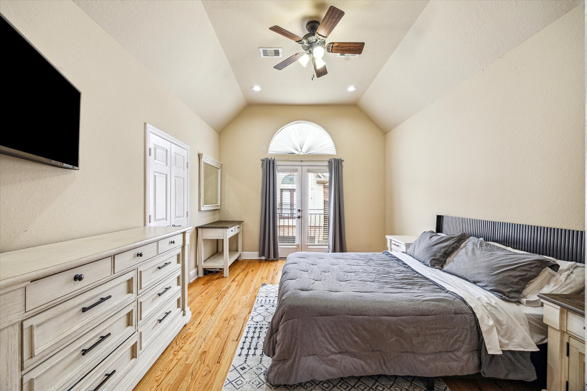 210 Grove Street Houston, TX 77020 - Photo 12 of 28 a spacious bedroom with a large bed and a flat tv screen on dresser