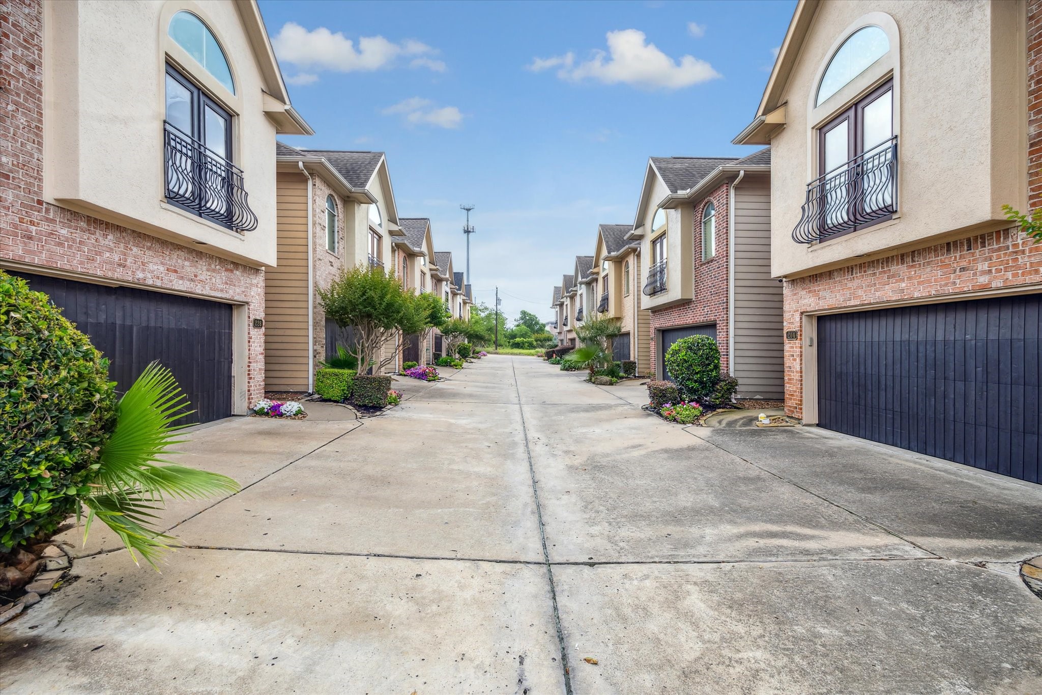 a sidewalk with a building and trees in the background