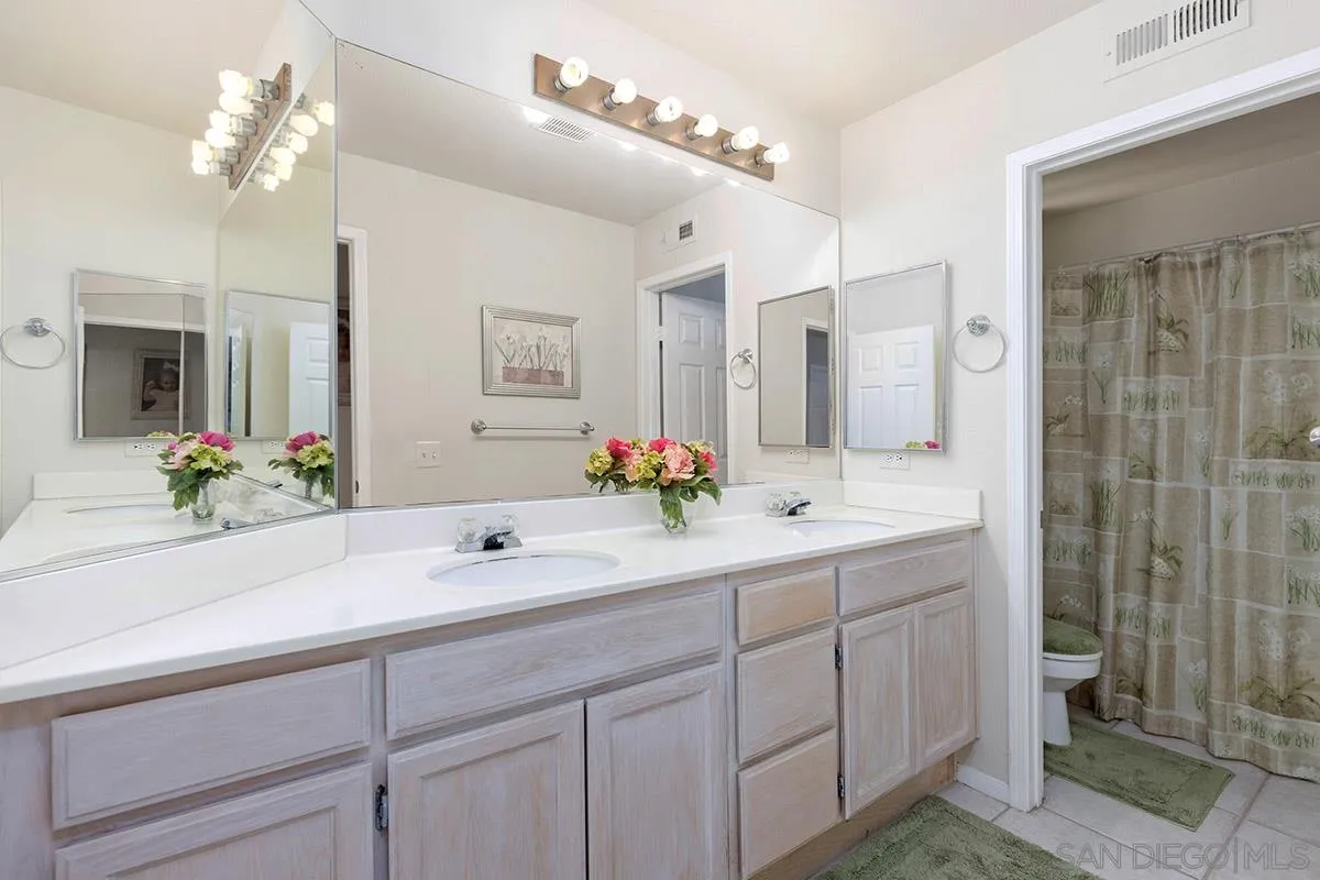 1690 West 11th Avenue Escondido, CA 92029 - Photo 22 of 25 a bathroom with a double vanity sink mirror and shower