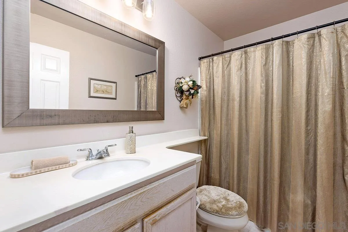 1690 West 11th Avenue Escondido, CA 92029 - Photo 25 of 25 a bathroom with a sink a toilet and shower curtain
