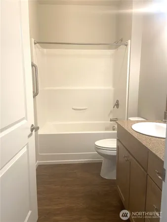 a bathroom with a granite countertop sink toilet and shower