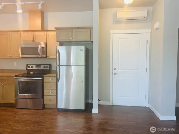 a kitchen with a refrigerator and a stove top oven