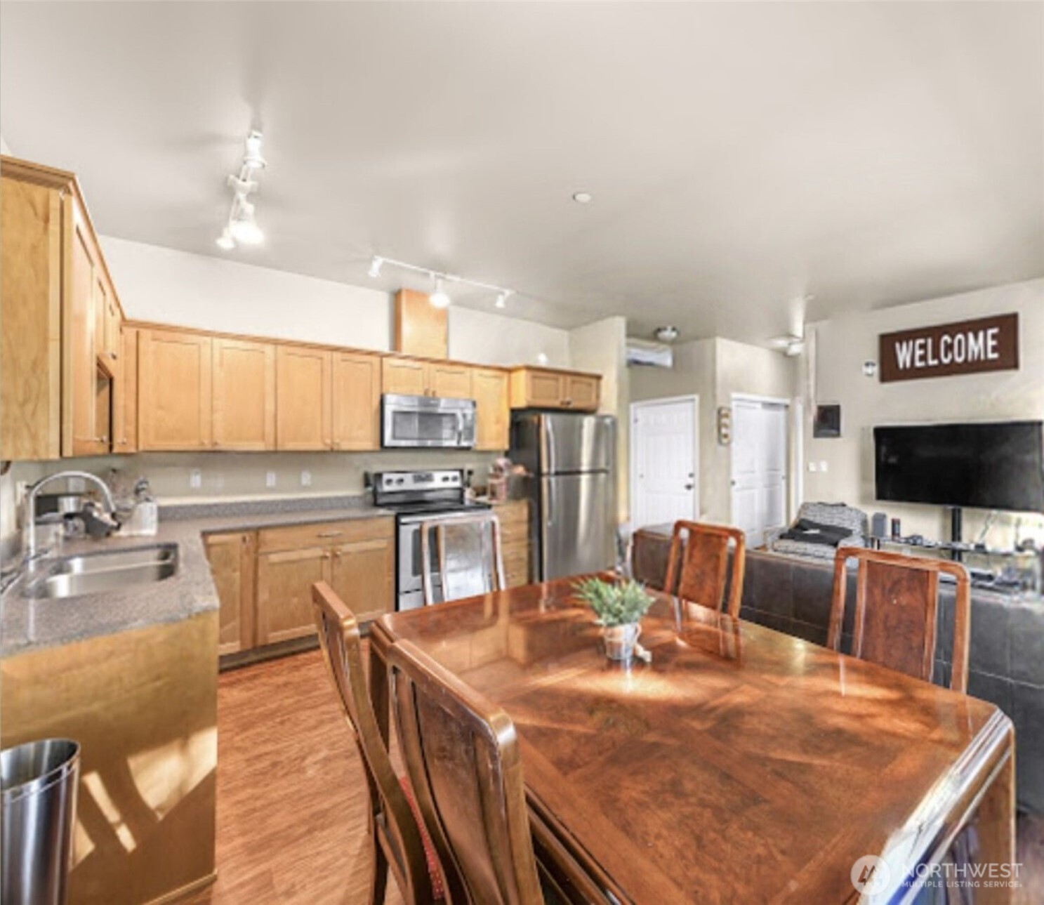 8872 Depot Road, Unit 203 Lynden, WA 98264 - Photo 7 of 15 a kitchen with stainless steel appliances kitchen island granite countertop a table chairs and a refrigerator