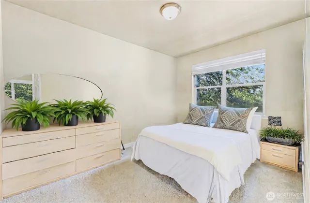 a bedroom with a large bed and a potted plant