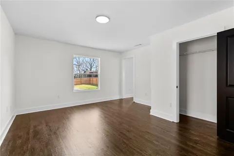 an empty room with wooden floor and window