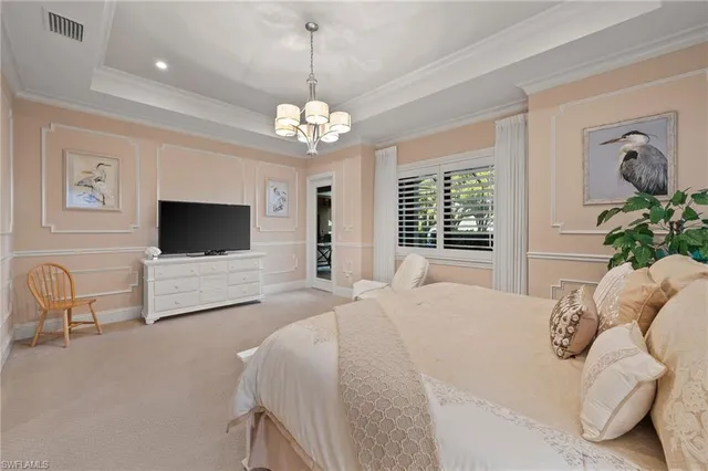 a spacious bedroom with a bed and a flat screen tv