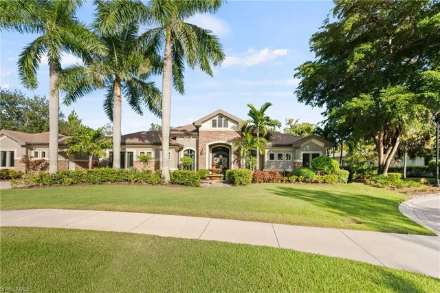 a view of a big house with a big yard and palm trees