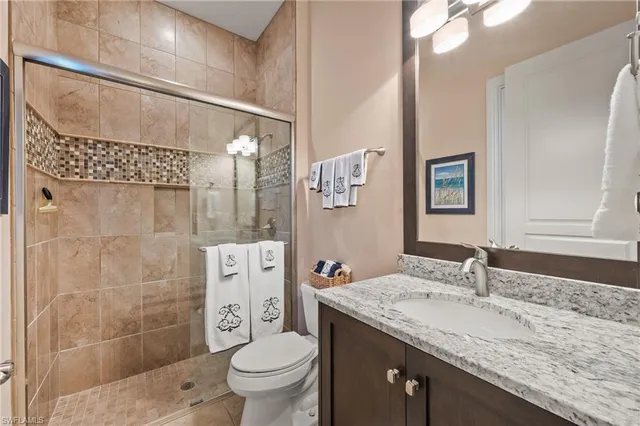 a bathroom with a granite countertop sink toilet and shower