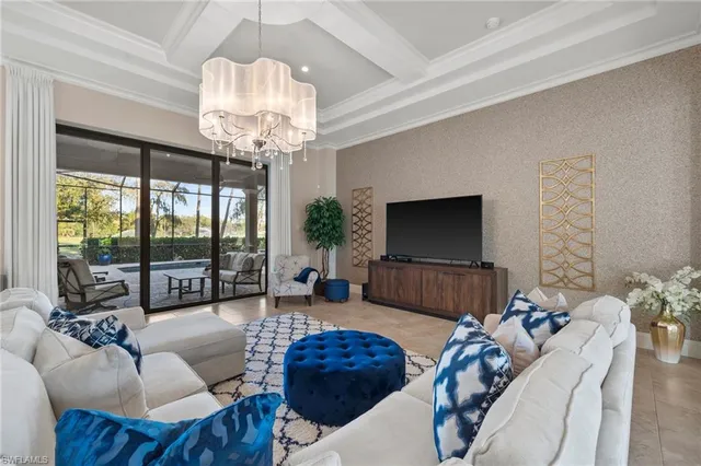 a living room with furniture a chandelier and a flat screen tv
