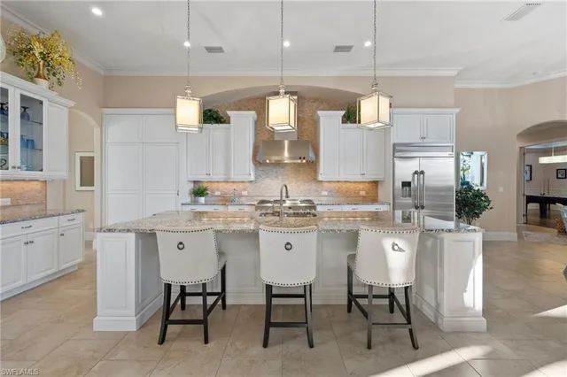a kitchen with cabinets and chairs