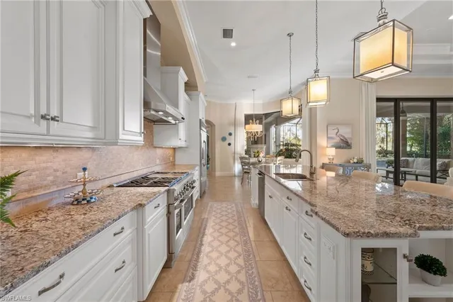 a large kitchen with granite countertop a sink and dishwasher a stove oven with wooden floor