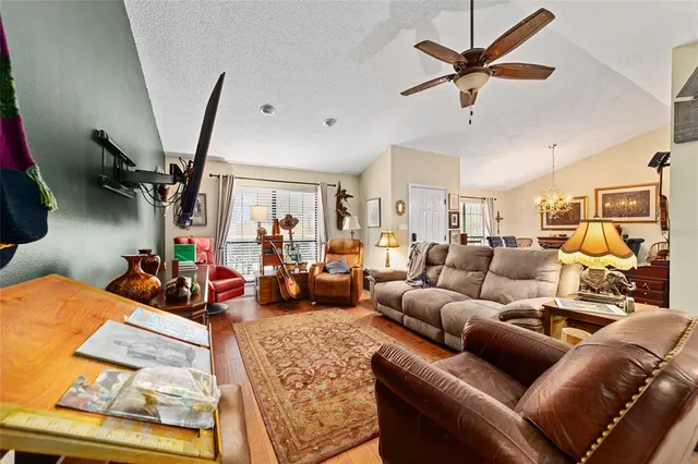 a living room with furniture a ceiling fan and a rug
