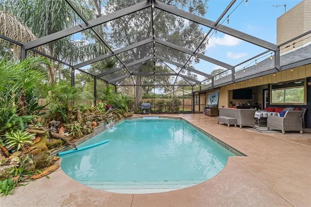a view of a swimming pool with a patio and a backyard