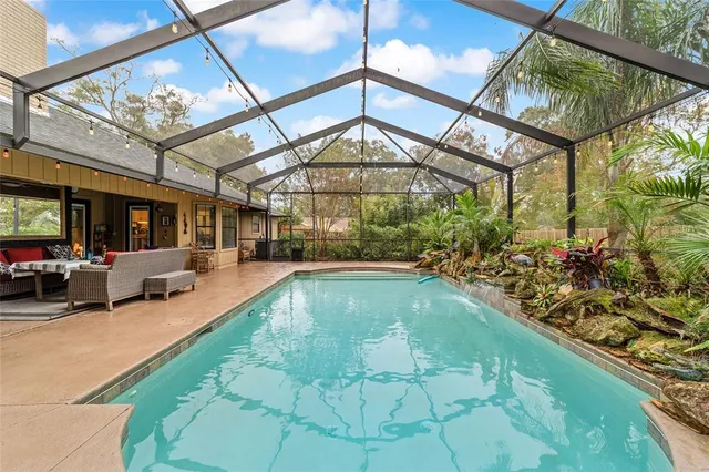 a swimming pool with lawn chairs and couches