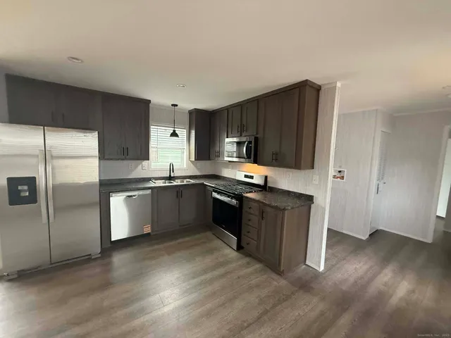 a large kitchen with a refrigerator and a stove top oven