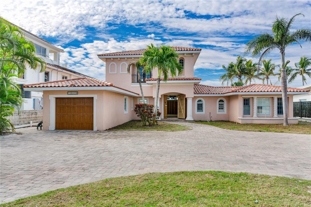 16116 Gulf Boulevard Redington Beach, FL 33708 - Photo 5 of 49 a front view of a house with a yard and garage