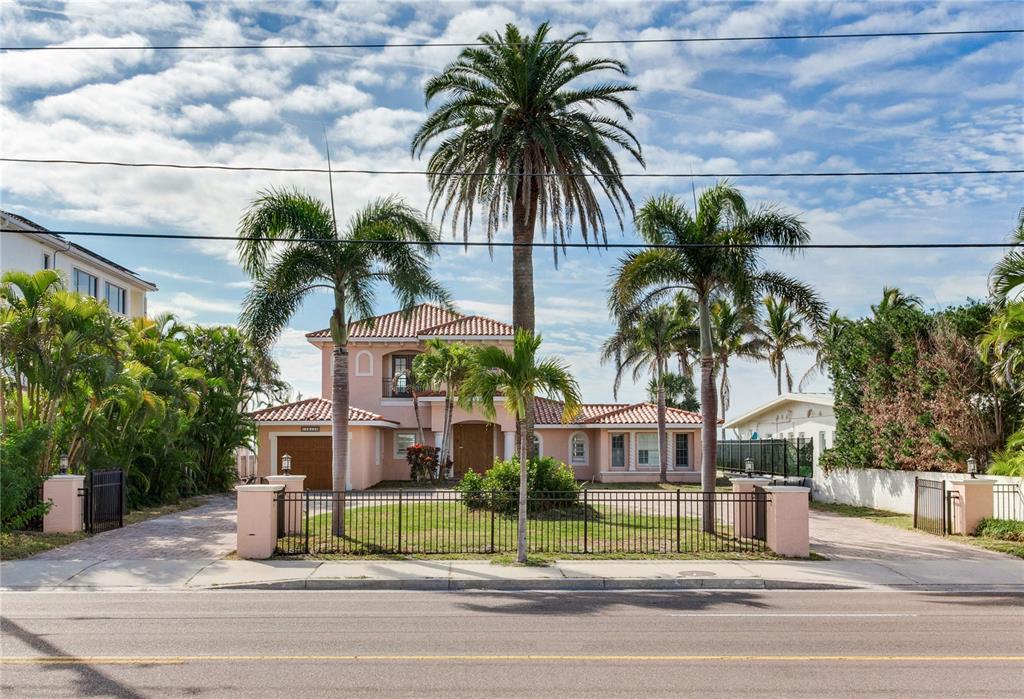 16116 Gulf Boulevard Redington Beach, FL 33708 - Photo 9 of 49 a view of a house with a yard and palm trees
