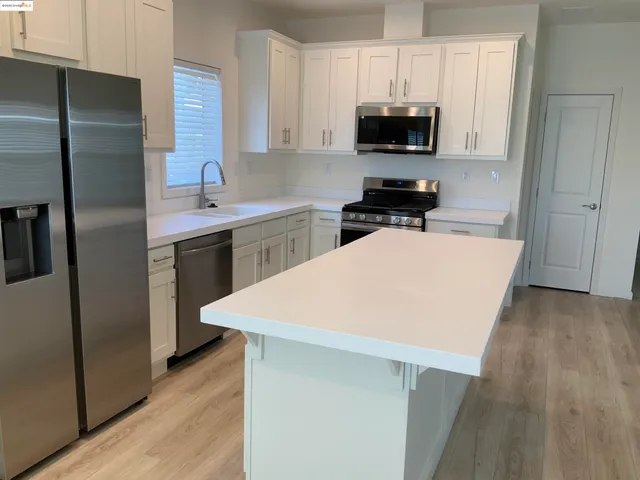 a kitchen with a sink a refrigerator and a stove